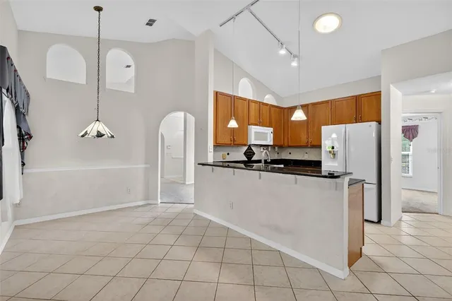 a kitchen with granite countertop a sink stove and cabinets
