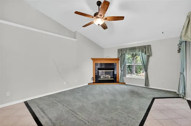 a view of a livingroom with a fireplace and a ceiling fan