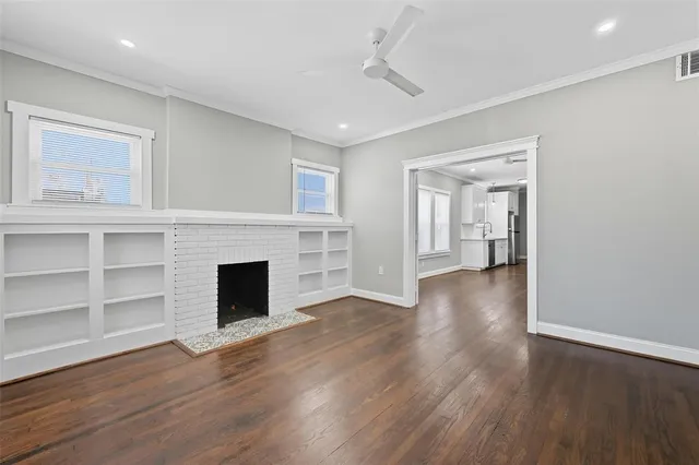 a view of a livingroom with wooden floor a fireplace and window