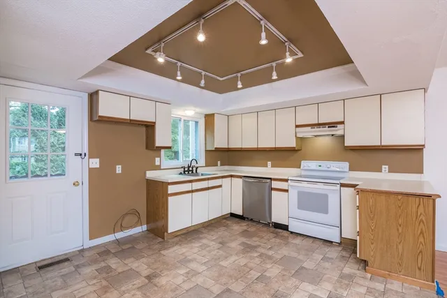 a kitchen with granite countertop appliances a sink and cabinets