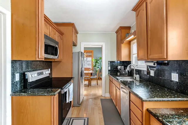 a kitchen with granite countertop a sink stove and refrigerator