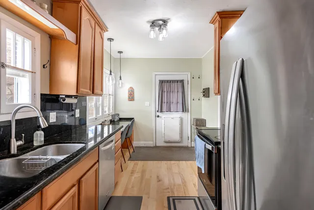 a kitchen with granite countertop a sink window and cabinets