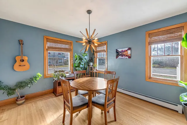 a dining room with furniture potted plants and wooden floor