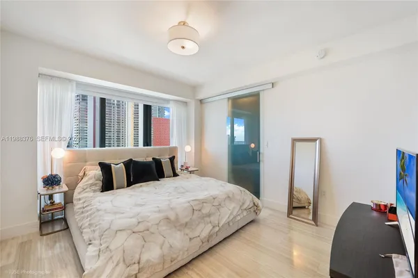 a bedroom with a large bed and a window