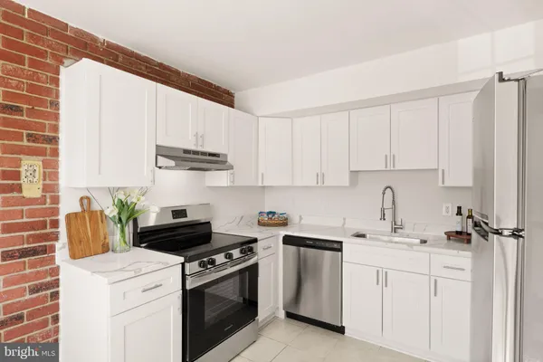 a kitchen with cabinets appliances a sink and a counter top space