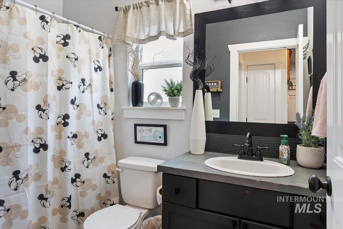 389 Arrow Street Twin Falls, ID 83301 - Photo 19 of 34 Bathroom with vanity, a shower with curtain, and decorative backsplash