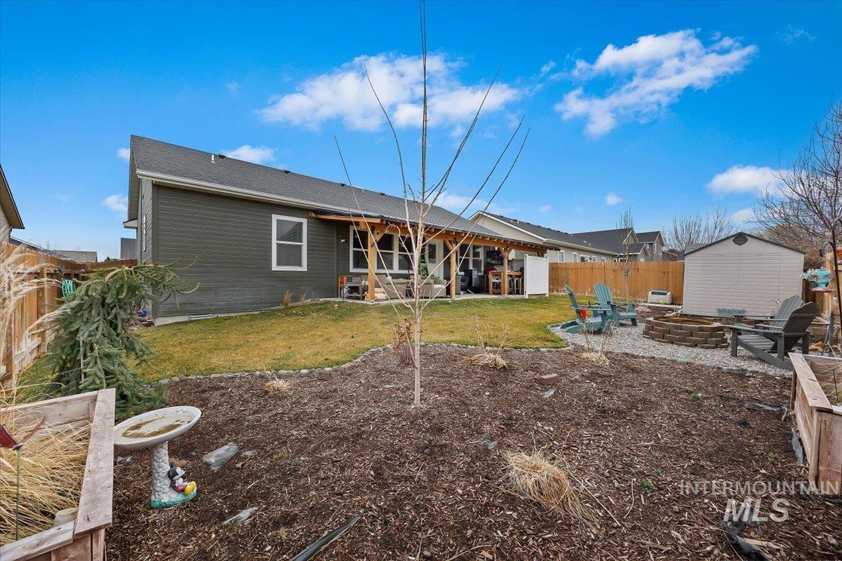 389 Arrow Street Twin Falls, ID 83301 - Photo 22 of 34 Rear view of house featuring a patio area, a fire pit, a storage unit, and a fenced backyard