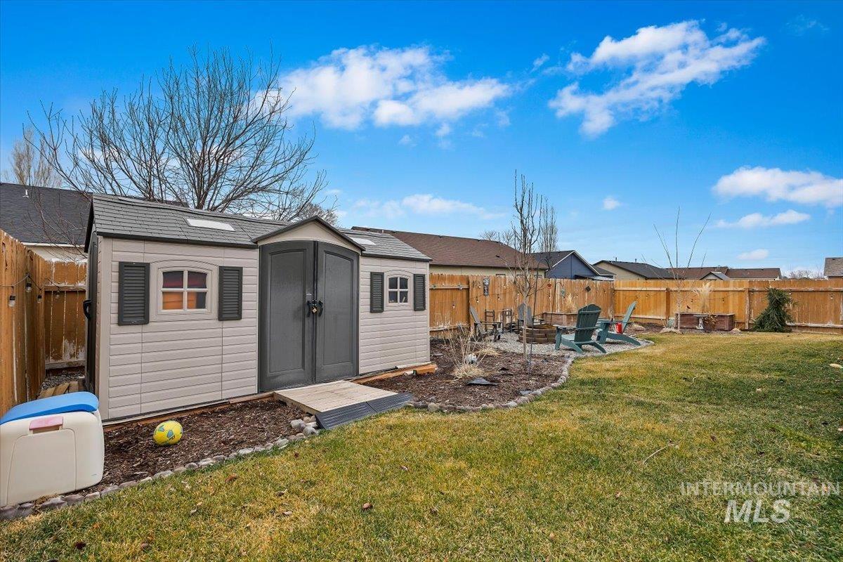389 Arrow Street Twin Falls, ID 83301 - Photo 24 of 34 Fenced backyard featuring a fire pit, a shed, and a patio