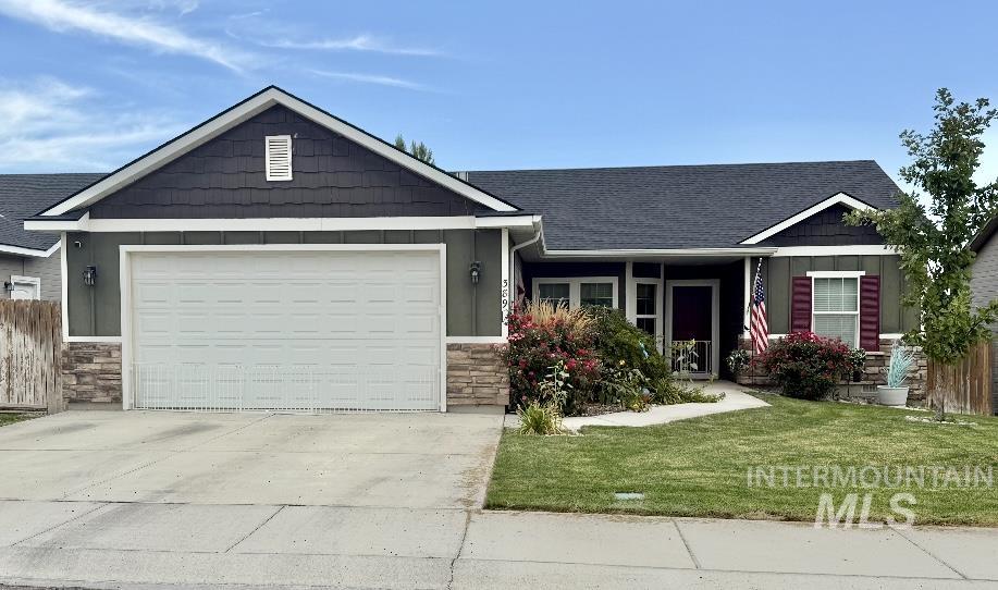 389 Arrow Street Twin Falls, ID 83301 - Photo 26 of 34 Craftsman inspired home with stone siding, a front yard, driveway, roof with shingles, and an attached garage