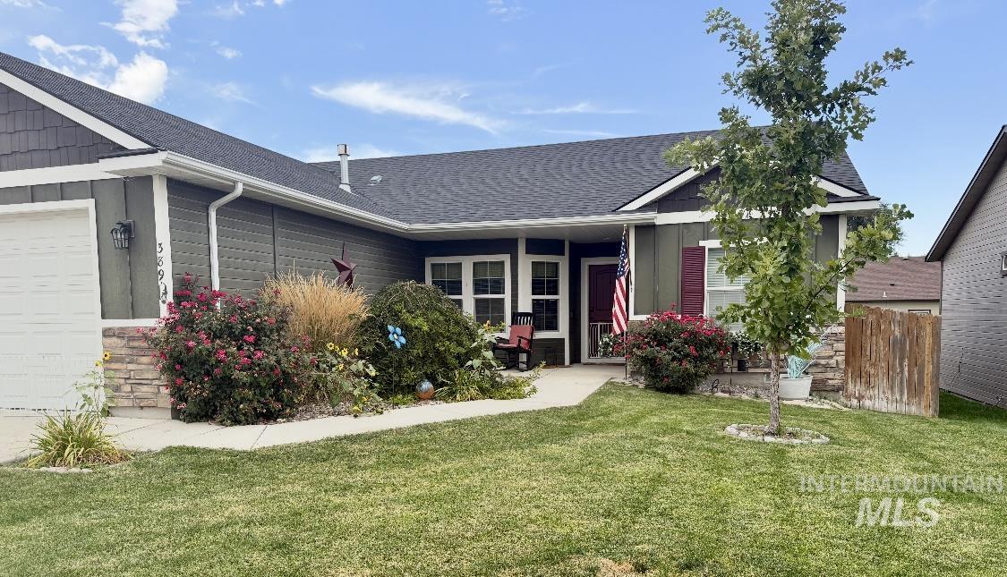 389 Arrow Street Twin Falls, ID 83301 - Photo 27 of 34 View of front of home featuring roof with shingles, a front yard, board and batten siding, and an attached garage
