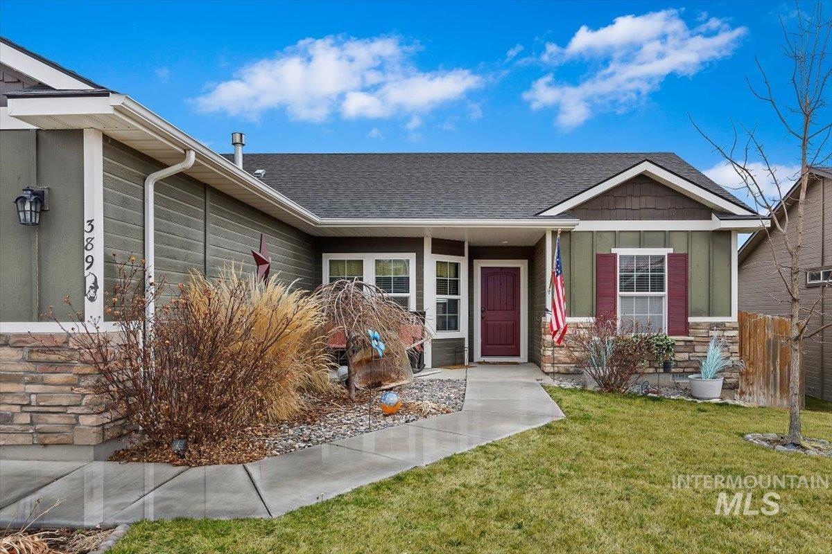 389 Arrow Street Twin Falls, ID 83301 - Photo 3 of 34 View of front of house featuring board and batten siding, stone siding, a front yard, covered porch, and roof with shingles