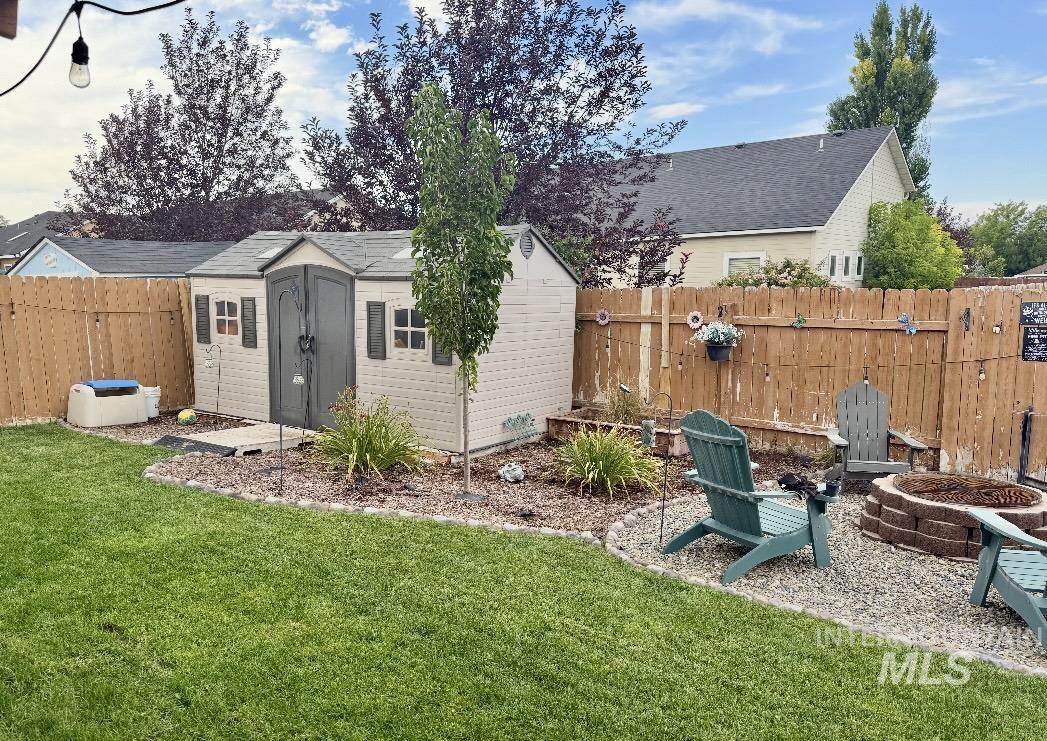 389 Arrow Street Twin Falls, ID 83301 - Photo 30 of 34 Fenced backyard featuring a fire pit and a storage shed