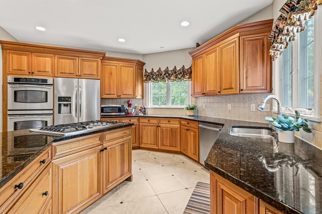 11 Pondview Lane Reading, MA 01867 - Photo 12 of 42 a kitchen with stainless steel appliances granite countertop a sink a stove and a refrigerator