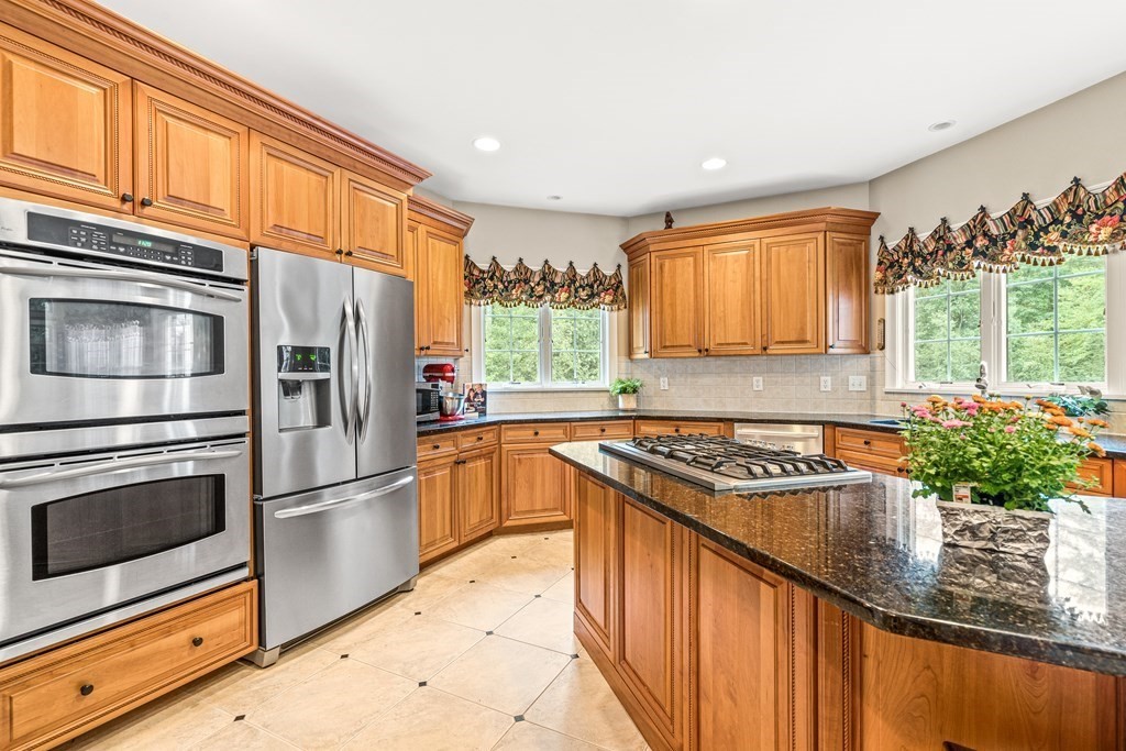 11 Pondview Lane Reading, MA 01867 - Photo 13 of 42 a kitchen with stainless steel appliances granite countertop a refrigerator and a sink