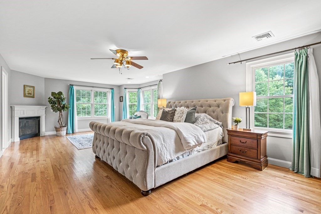 11 Pondview Lane Reading, MA 01867 - Photo 24 of 42 a spacious bedroom with a large bed a chandelier and windows