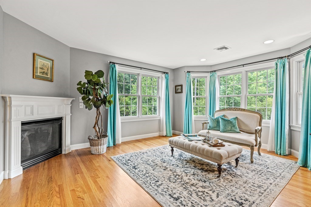 11 Pondview Lane Reading, MA 01867 - Photo 25 of 42 a living room with furniture and a fireplace