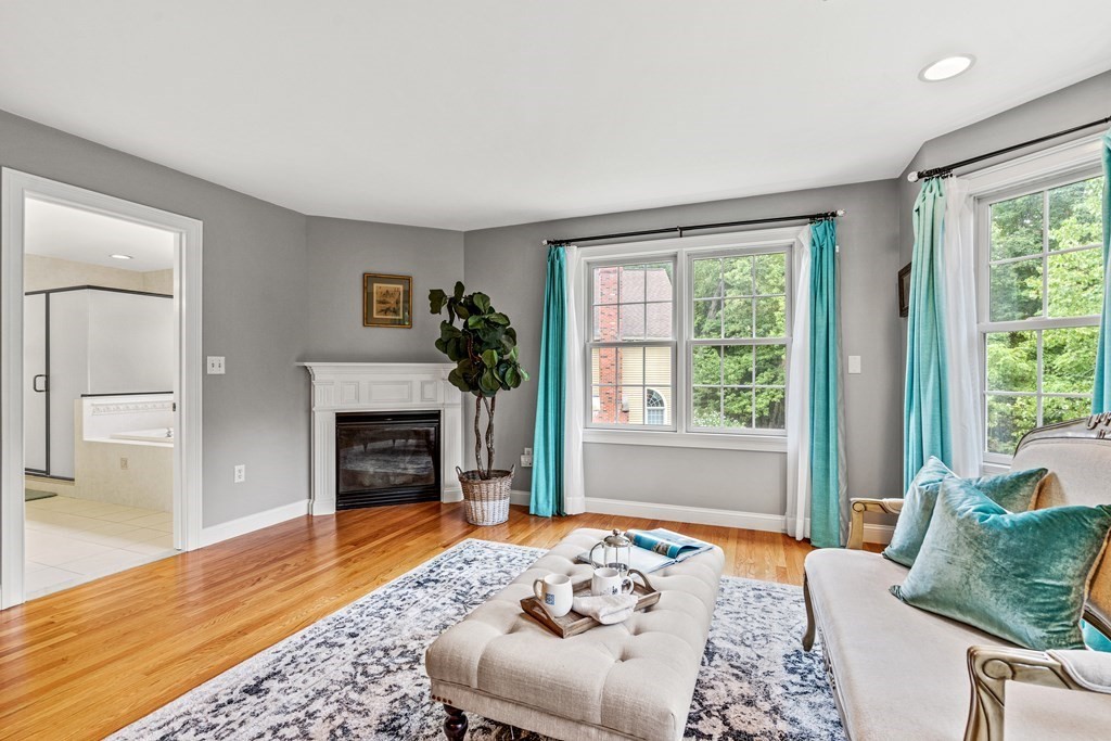 11 Pondview Lane Reading, MA 01867 - Photo 27 of 42 a bedroom with furniture and a fireplace