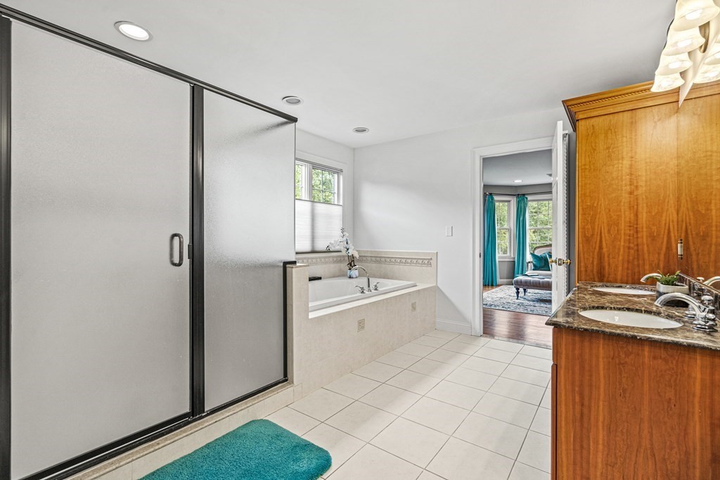 11 Pondview Lane Reading, MA 01867 - Photo 28 of 42 a large bathroom with a tub a sink and mirror