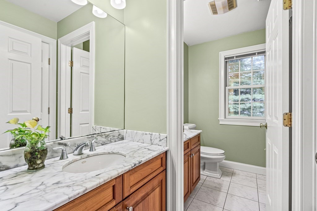 11 Pondview Lane Reading, MA 01867 - Photo 32 of 42 a bathroom with a granite countertop sink a toilet a large mirror and shower