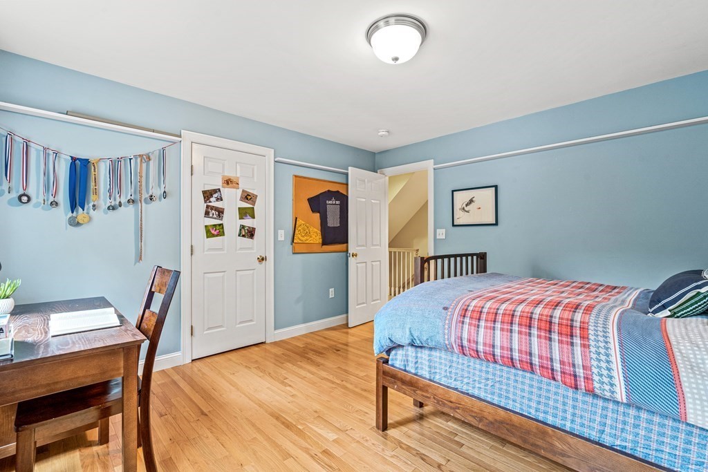 11 Pondview Lane Reading, MA 01867 - Photo 34 of 42 a bedroom with a bed and wooden floor