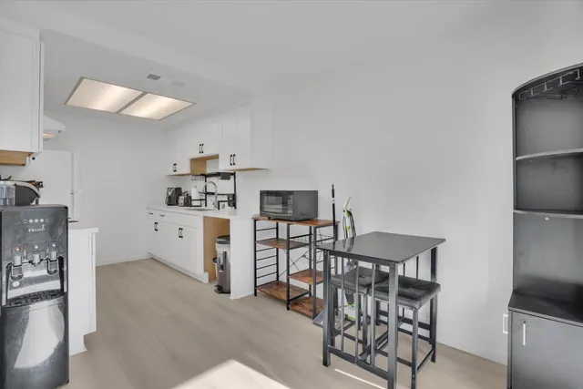 a kitchen with stainless steel appliances a table and chairs in it