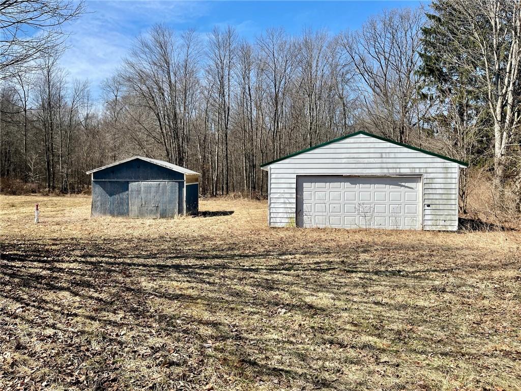 483 Hartwick Road Mercer, PA 16137 - Photo 1 of 10 a backyard of a house with large trees and wooden fence