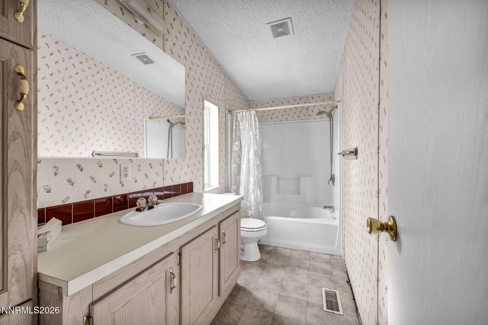 5107 Leon Drive Sun Valley, NV 89433 - Photo 17 of 43 a bathroom with a double vanity sink toilet mirror and bathtub