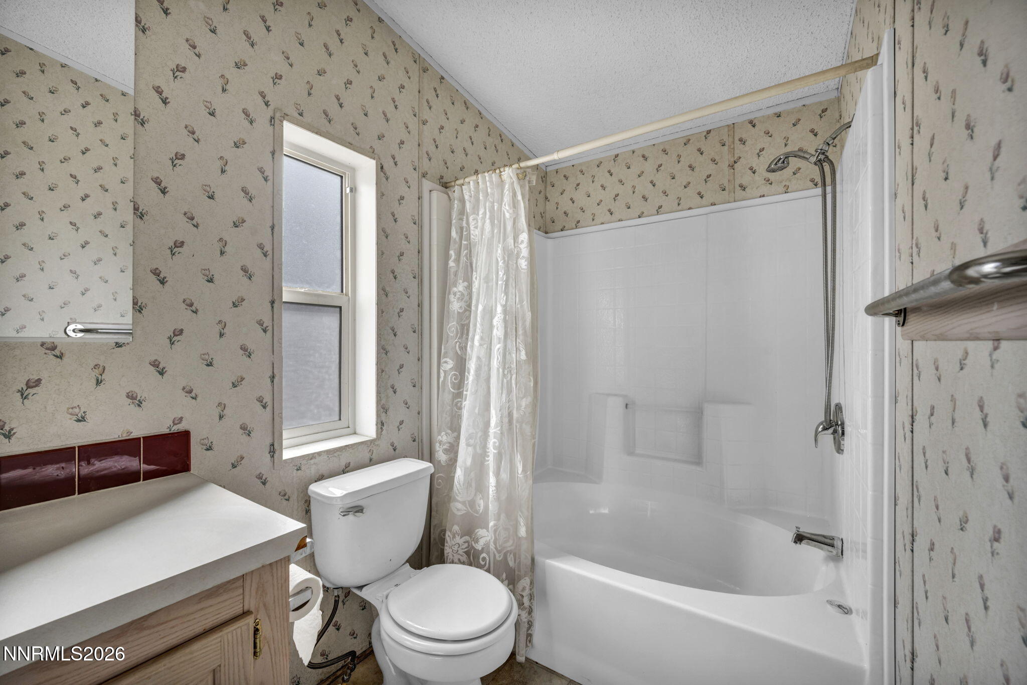 5107 Leon Drive Sun Valley, NV 89433 - Photo 18 of 43 a white toilet sitting next to a bathroom sink