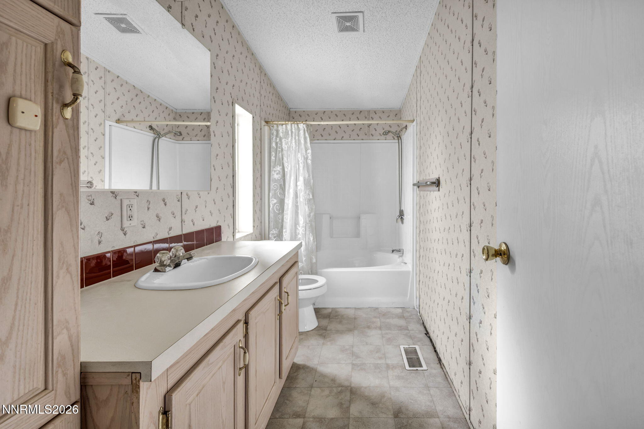 5107 Leon Drive Sun Valley, NV 89433 - Photo 19 of 43 a bathroom with a sink a toilet a mirror and shower