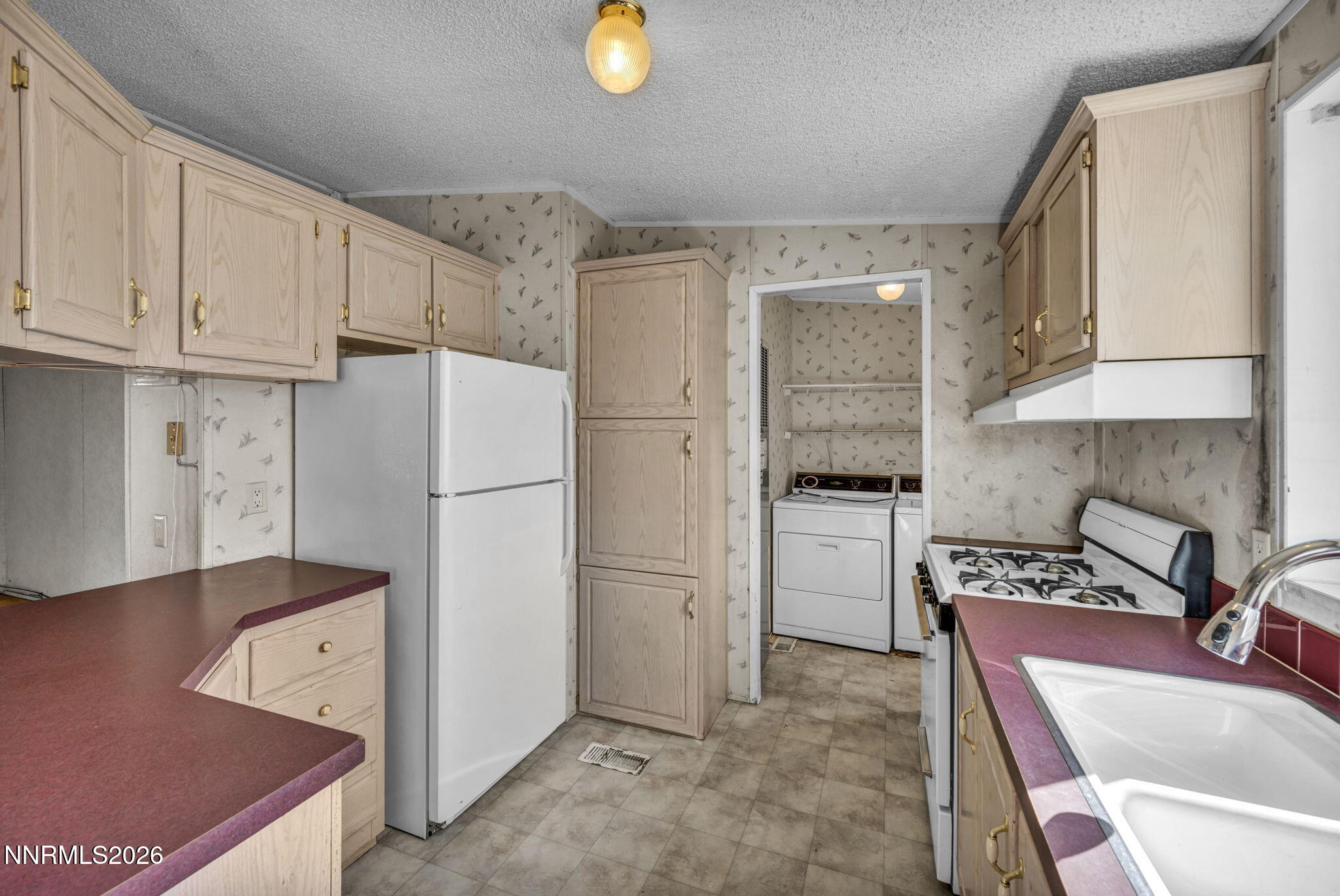 5107 Leon Drive Sun Valley, NV 89433 - Photo 5 of 43 a kitchen with refrigerator and cabinets