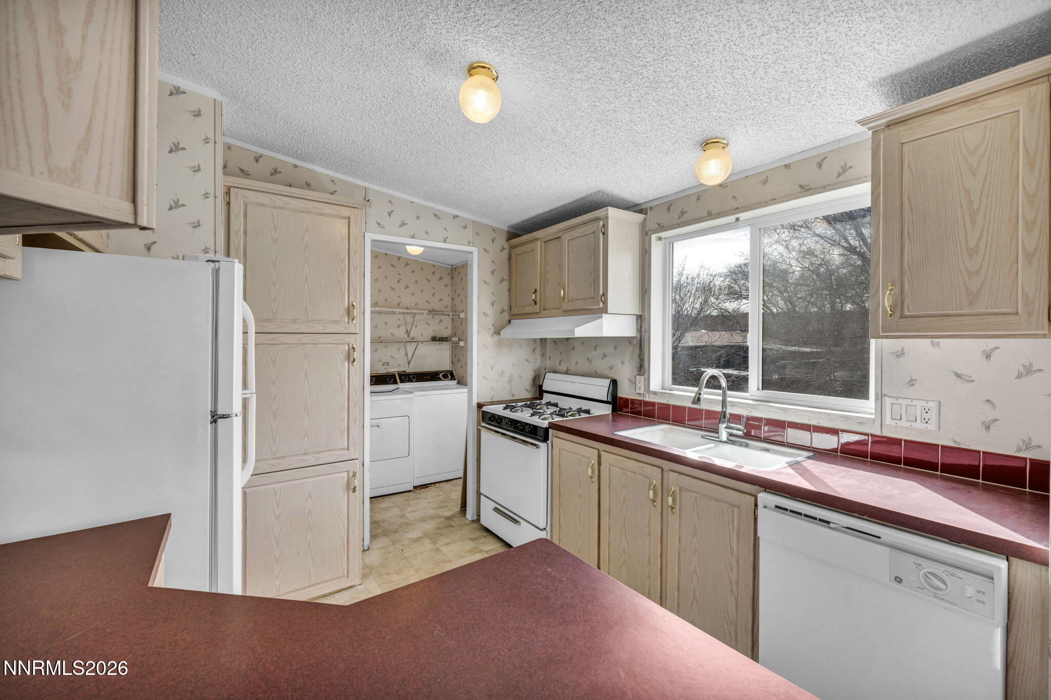 5107 Leon Drive Sun Valley, NV 89433 - Photo 7 of 43 a kitchen with a sink window and refrigerator