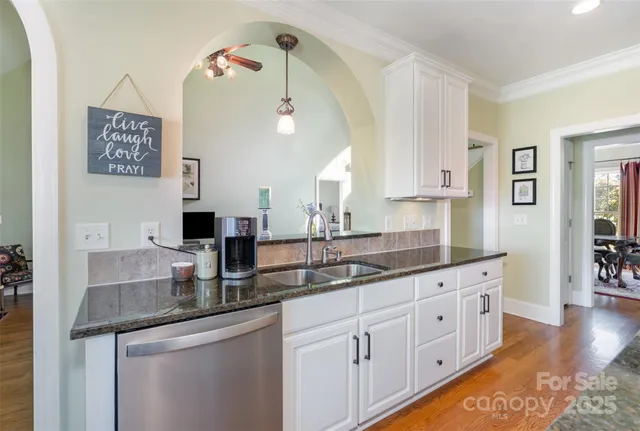 a kitchen with kitchen island granite countertop a sink cabinets and stainless steel appliances