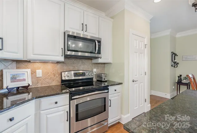 a kitchen with white cabinets and stainless steel appliances