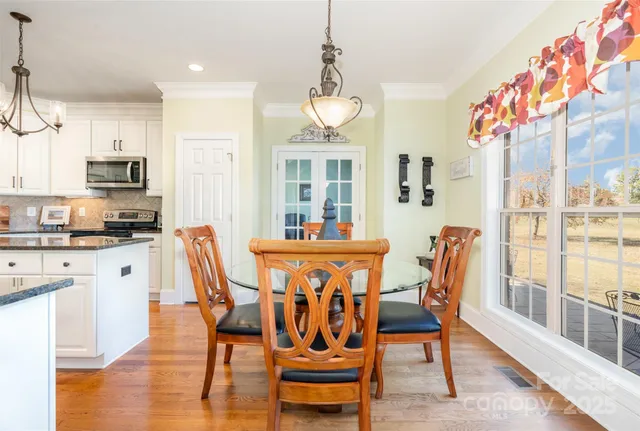 a dining room with furniture a chandelier and wooden floor