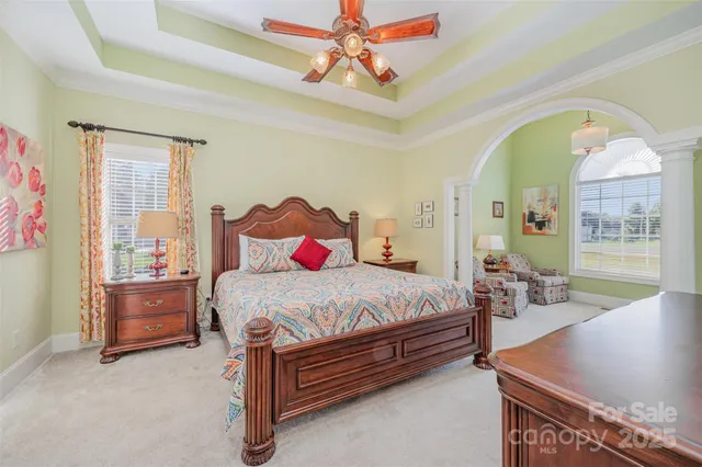 a bedroom with a bed a dresser and potted plant on the table