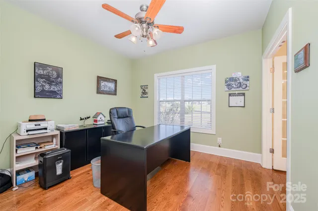 a view of a workspace with furniture and a window