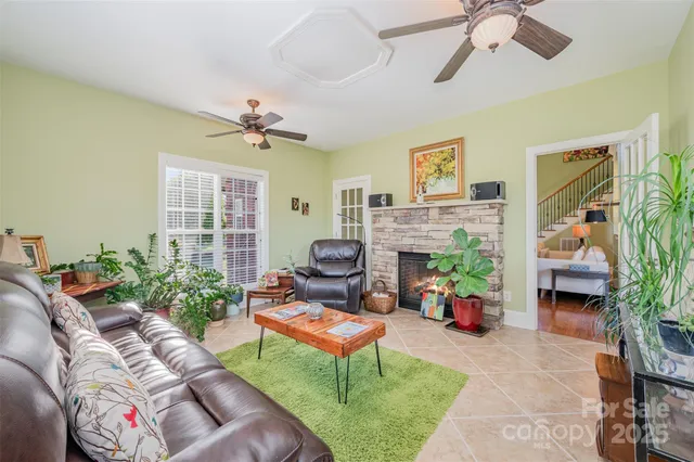 a living room with furniture a fireplace and a potted plant