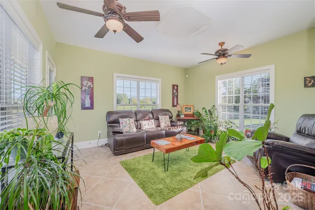 a living room with patio furniture and a floor to ceiling window