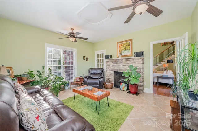 a living room with furniture a fireplace and a potted plant