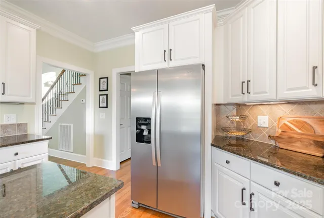 a kitchen with granite countertop a refrigerator and a sink