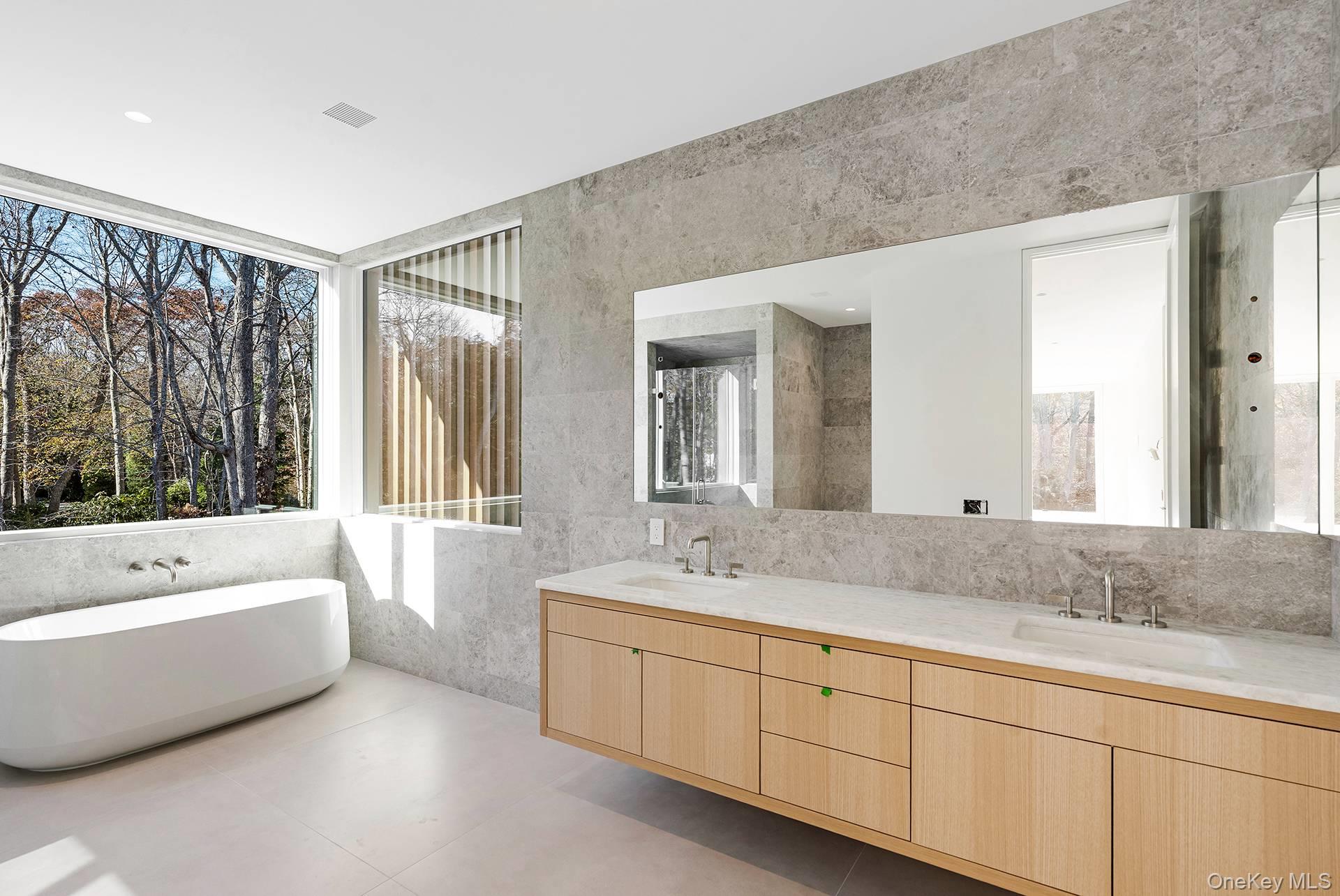 16 Arbor Path Amagansett, NY 11930 - Photo 9 of 10 a spacious bathroom with a double vanity sink large mirror and a bathtub