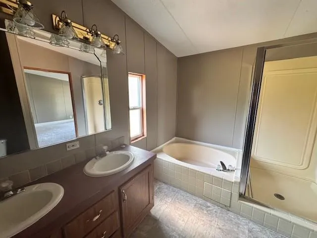 a bathroom with a tub sink and mirror