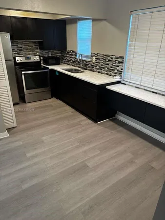 a kitchen with stainless steel appliances wooden cabinets and a stove top oven