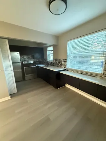 a large white kitchen with a large window