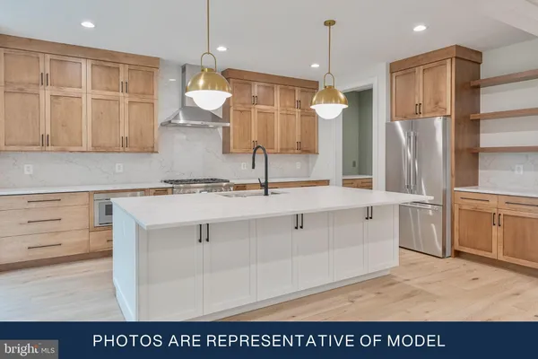 a kitchen with kitchen island white cabinets and refrigerator