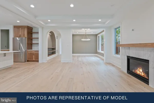 a view of kitchen and empty room with fireplace