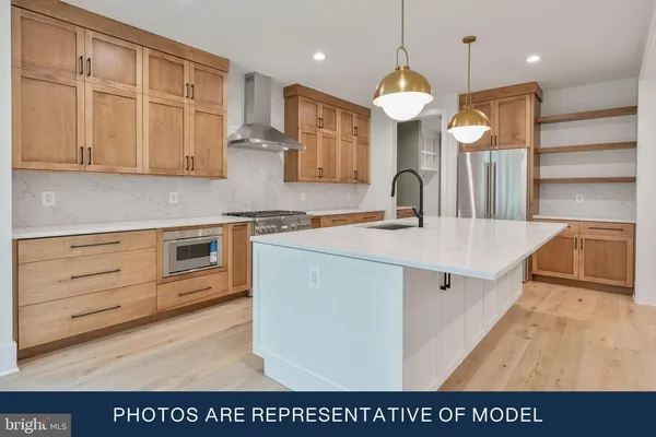 a kitchen with kitchen island granite countertop a sink a stove and a wooden floors