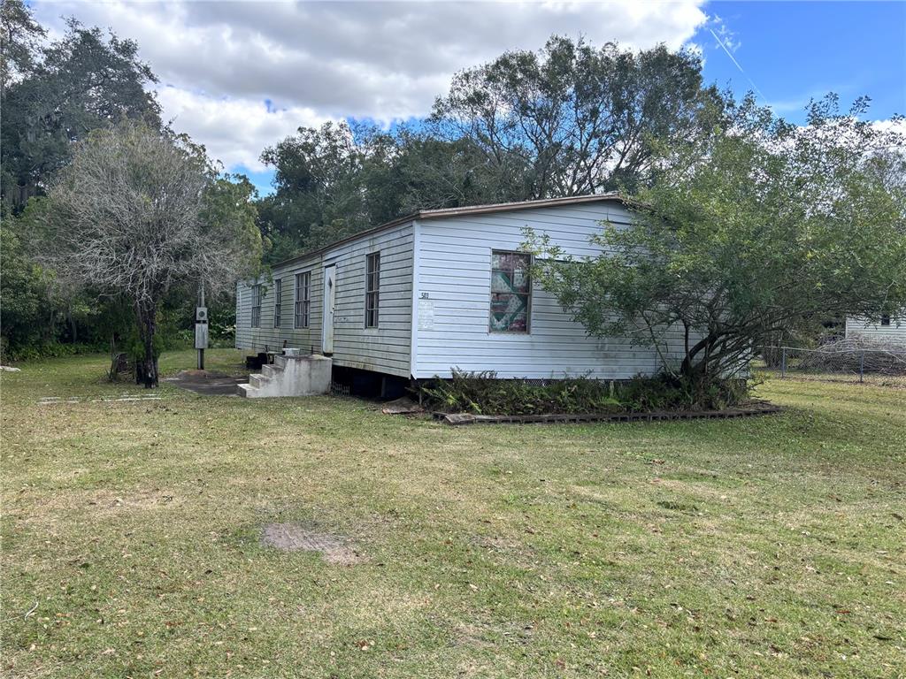 a backyard of a house with table and chairs