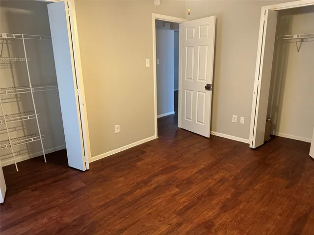 an empty room with wooden floor and entrance