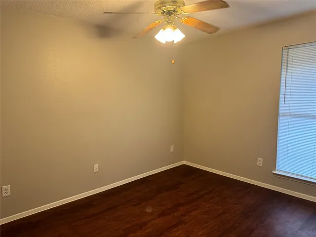 a view of a room with wooden floor and fan